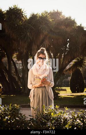 Young woman reading book, Parc de la Ciutadella, Barcelone, Espagne Banque D'Images