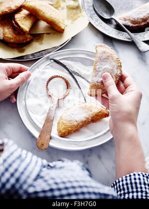 Over shoulder high angle view of mid adult man holding peach pie main Banque D'Images