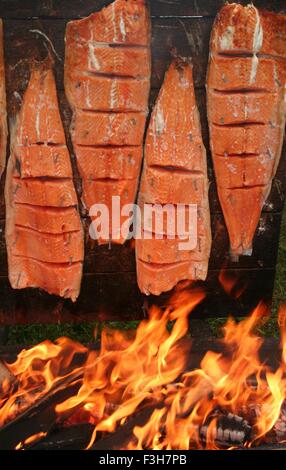 Des saumons, loimulohi «' en finnois, la cuisson à feu ouvert. Banque D'Images