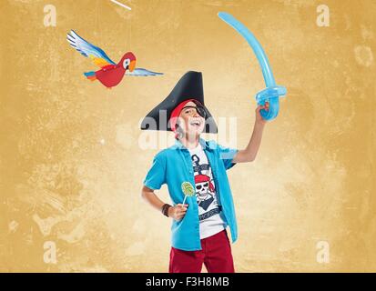 Boy wearing pirate costume et cache-oeil holding balloon épée et Lucette, smiling at camera Banque D'Images