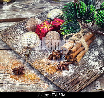 Décorations de Noël à l'ancienne,les bâtons de cannelle, l'anis étoilé et les écrous à l'arrière-plan rétro en bois Banque D'Images