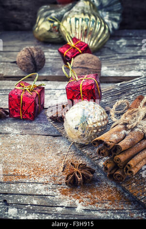 Décorations de Noël à l'ancienne,les bâtons de cannelle, l'anis étoilé et les écrous à l'arrière-plan rétro en bois Banque D'Images