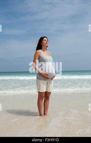 Enceinte Mid adult woman standing avec les yeux fermé en mer Banque D'Images