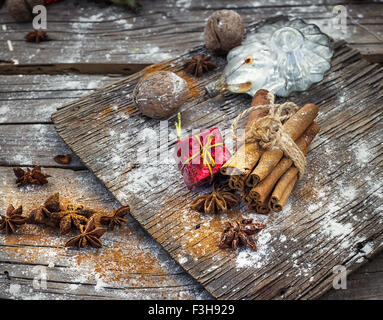 Décorations de Noël à l'ancienne,les bâtons de cannelle, l'anis étoilé et les écrous à l'arrière-plan rétro en bois Banque D'Images