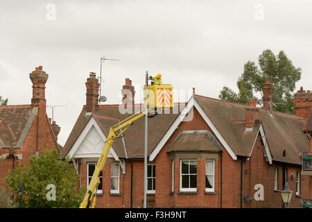 L'homme du Conseil (employé) dans 'nacelle' peinture de levage de la flèche haut du réverbère à Bedford, Bedfordshire, Angleterre Banque D'Images