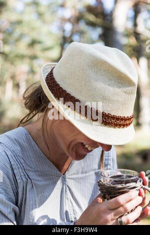 Femme mature de rire tandis que la consommation de thé dans la région de forest Banque D'Images