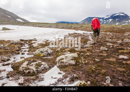 Vue arrière du jeune homme randonnée dans le paysage gelé, Oural, Russie Banque D'Images