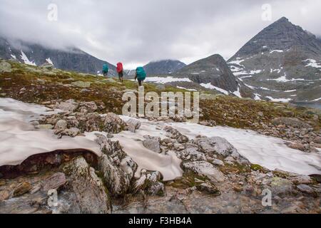 Vue arrière de trois randonneurs randonnées à travers le paysage gelé, Oural, Russie Banque D'Images