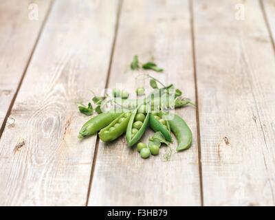 La vie encore de petits pois en dosettes avec pousses de pois sur table en bois Banque D'Images