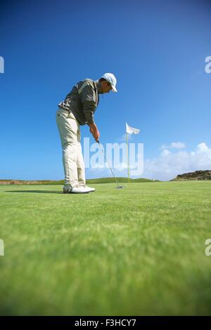Toute la longueur de l'angle faible vue latérale du golfeur mettre Banque D'Images