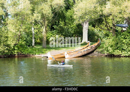 Adolescente en kayak sur le lac Ontario lignes passé deux canoës et les personnes ayant un barbecue sur l'île Centre à Toronto, Ontario, Canada Banque D'Images