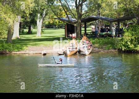 Adolescente en kayak sur le lac Ontario lignes passé deux canoës et les personnes ayant un barbecue sur l'île Centre à Toronto, Ontario, Canada Banque D'Images