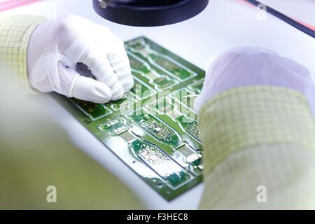 Jeune femme travaillant usine de production de cartes de circuits électroniques souples. Situé au sud de l'usine Chine Zhuhai Guangdong Province Banque D'Images