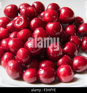 Bol d cerries frais rouge sur fond blanc Banque D'Images