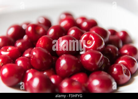 Bol d cerries frais rouge sur fond blanc Banque D'Images