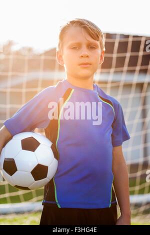 Portrait of boy holding football joueur de football face au but Banque D'Images