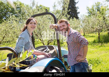 Jeune couple avec un tracteur à la caméra en souriant Banque D'Images