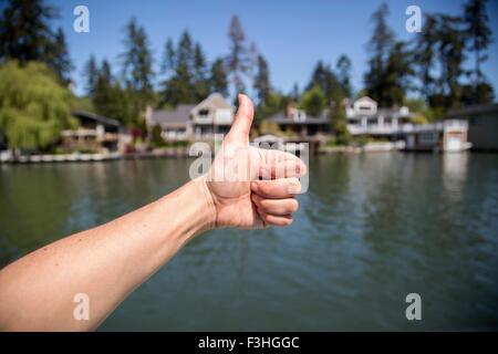 Main de jeune femme faisant Thumbs up sur le bord de mer, Lake Oswego, Oregon, USA Banque D'Images