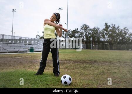 Joueur de football qui s'étend dans la zone Banque D'Images