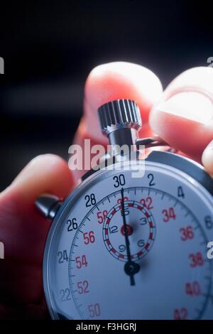 Cropped shot of hand holding silver stop watch Banque D'Images