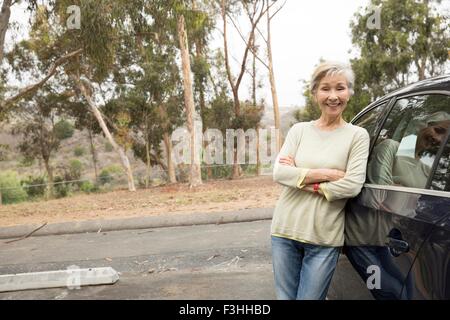 Portrait of senior woman leaning against location Banque D'Images