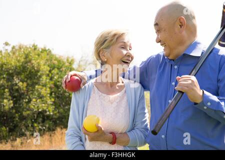 Portrait of senior couple in park, maillet de croquet et billes de holding Banque D'Images