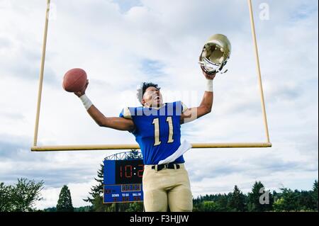 Teenage American football player célébrer sur terrain de football Banque D'Images