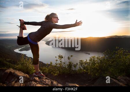 Woman practicing yoga on hill, Angel's Rest, Columbia River Gorge, Oregon, USA Banque D'Images