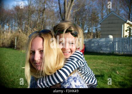 Mère de ferroutage donnant à fils en costume de super-héro Banque D'Images