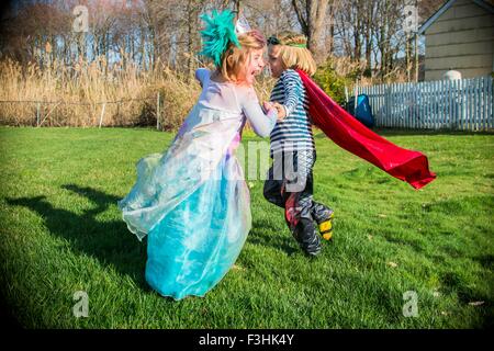 Les enfants en costumes jouent à l'extérieur Banque D'Images