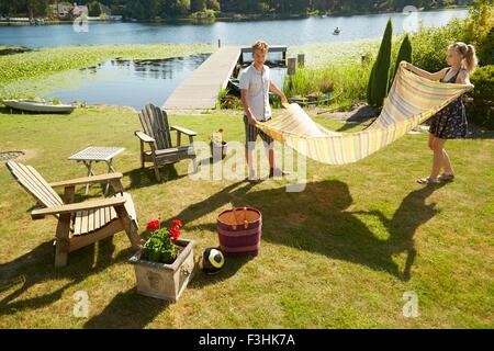 Couple laying couverture de pique-nique sur l'herbe, le lac en arrière-plan, Seattle, Washington, USA Banque D'Images