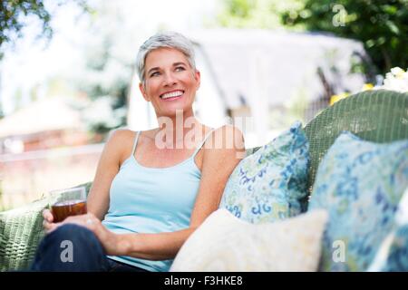 Young woman relaxing on garden seat Banque D'Images