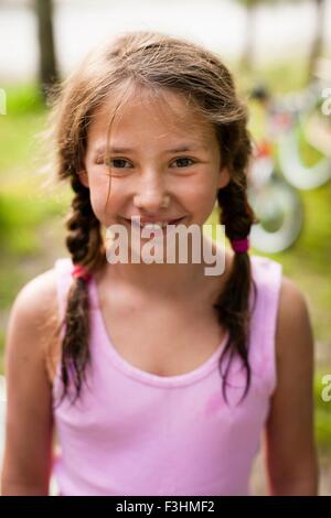 High angle portrait of young girl with pigtails smiling at camera Banque D'Images