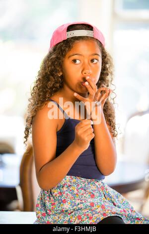 Girl licking fouetter le mélange à gâteau de doigts à l'écart Banque D'Images