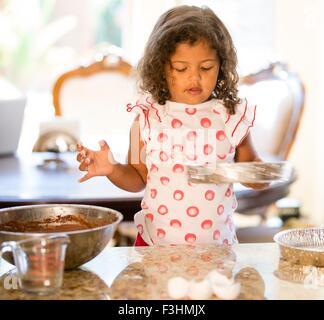 Fille au comptoir de la cuisine tenue à gâteau à la bas Banque D'Images