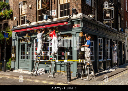 Les peintres et décorateurs peinture extérieure d'un pub, Shepherd Market, London, UK Banque D'Images