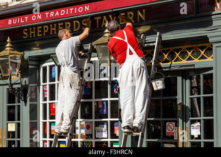 Les peintres et décorateurs peinture extérieure d'un pub, Shepherd Market, London, UK Banque D'Images