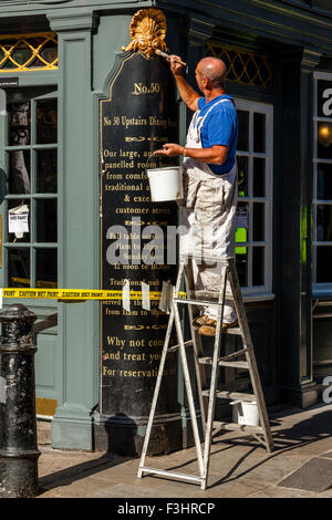 Les peintres et décorateurs peinture extérieure d'un pub, Shepherd Market, London, UK Banque D'Images