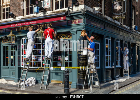 Les peintres et décorateurs peinture extérieure d'un pub, Shepherd Market, London, UK Banque D'Images