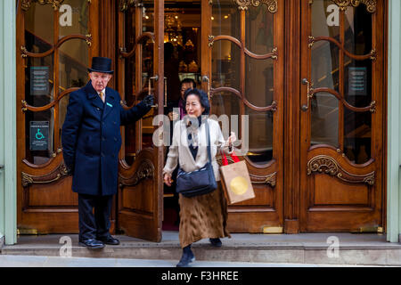 Portier à l'entrée de Fortnum and Mason Department Store ouvre la porte pour les clients, London, UK Banque D'Images