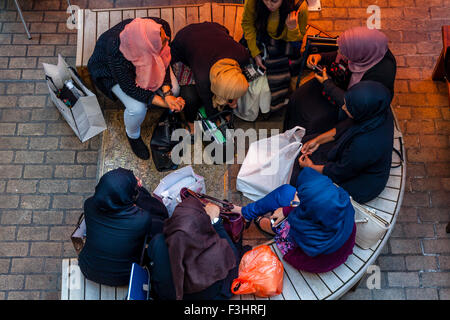 Jeunes femmes musulmanes Chat assis dans un café à Carnaby Street, London, UK Banque D'Images