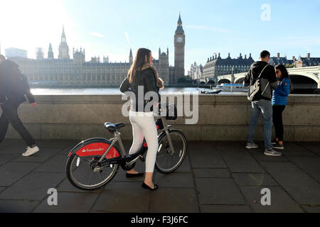 Jeune femme équitation tourisme Santander voitures vélo sur rue au pont de Westminster Big Ben et des chambres du Parlement et Tamise London UK KATHY DEWITT Banque D'Images