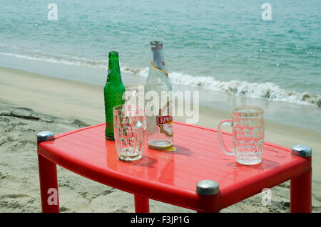 Bouteille de bière vide et les tasses sur la table en plastique à Devbaug Sindhudurgh ; plage ; Maharashtra Inde Banque D'Images