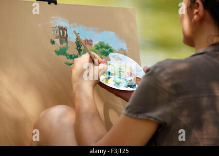 Une jeune fille peint un tableau dans le parc Banque D'Images