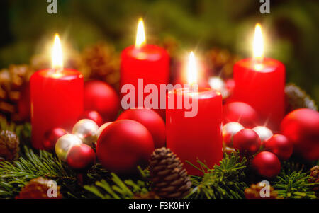 Studio shot d'une belle guirlande de noël et quatre bougies rouges en feu Banque D'Images