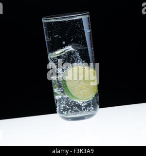 Le verre, glace, citron et Indian Tonic/close-up sur fond noir Banque D'Images