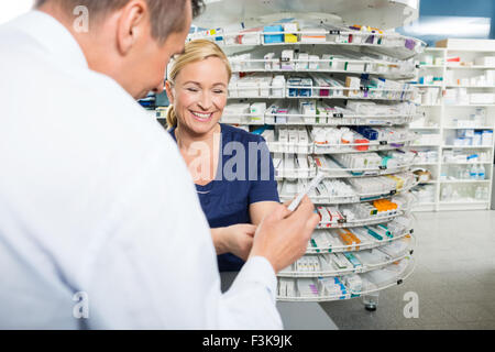 Pharmacien expliquant les détails du produit à la clientèle masculine Banque D'Images