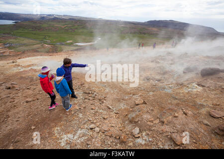 Les visiteurs à côté de la vapeur cheminées volcaniques à Seltun, zone géothermique Krysuvik, péninsule de Reykjanes, l'Islande. Banque D'Images