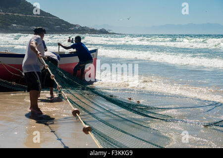 Trek aux pêcheurs de travailler pour stabiliser le bateau et tirer dans les filets, Fishhoek Bay, Afrique du Sud Banque D'Images