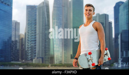 Smiling man with skateboard sur Singapour ville Banque D'Images